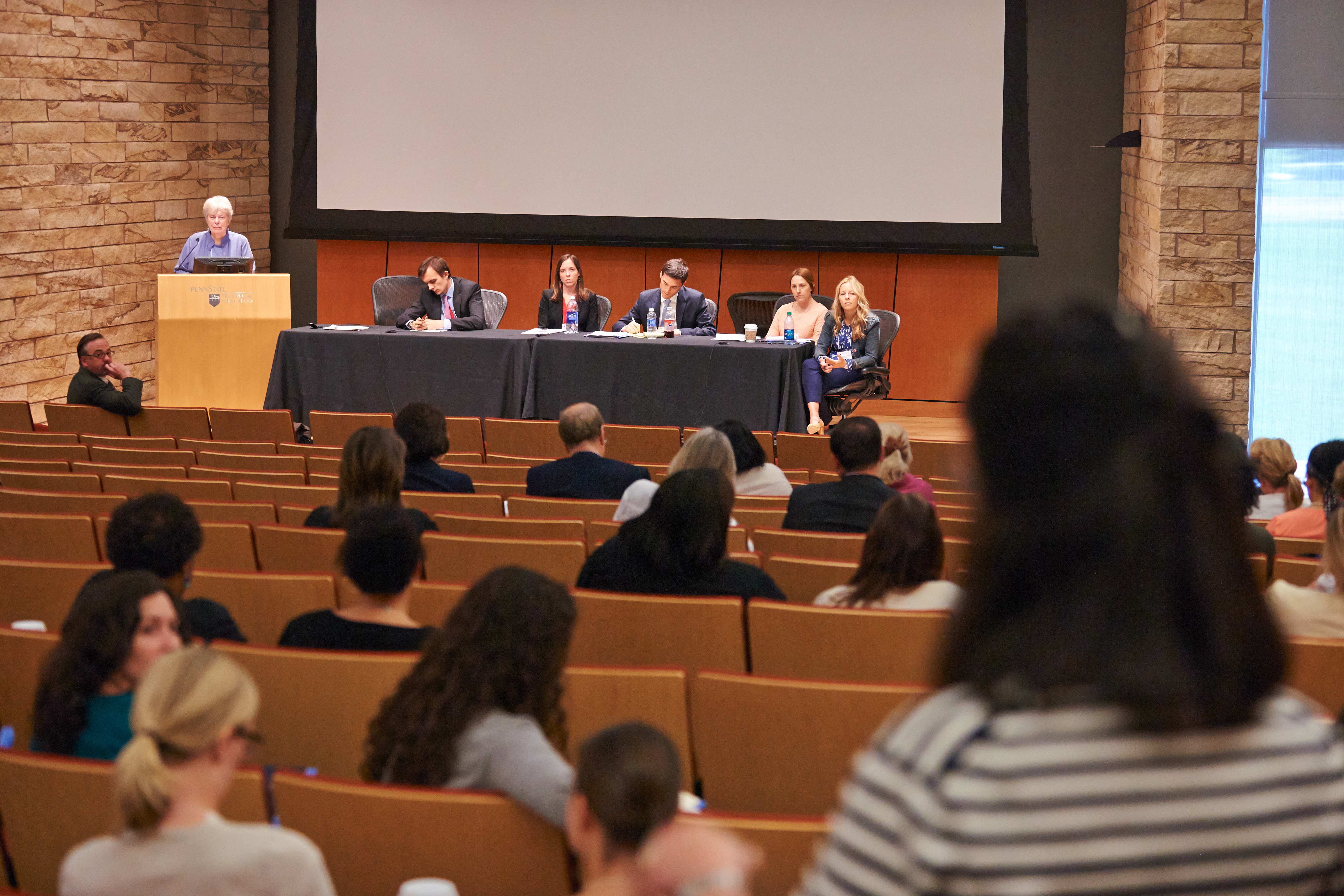 auditorium full of people with a panel on stage