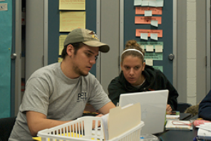 Two students looking at a computer. 